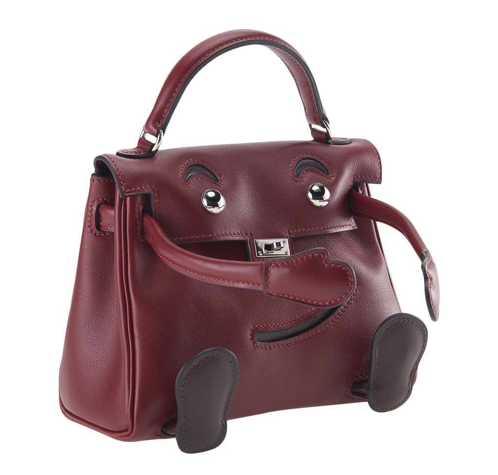 Maroon handbag with animal face design on a white background