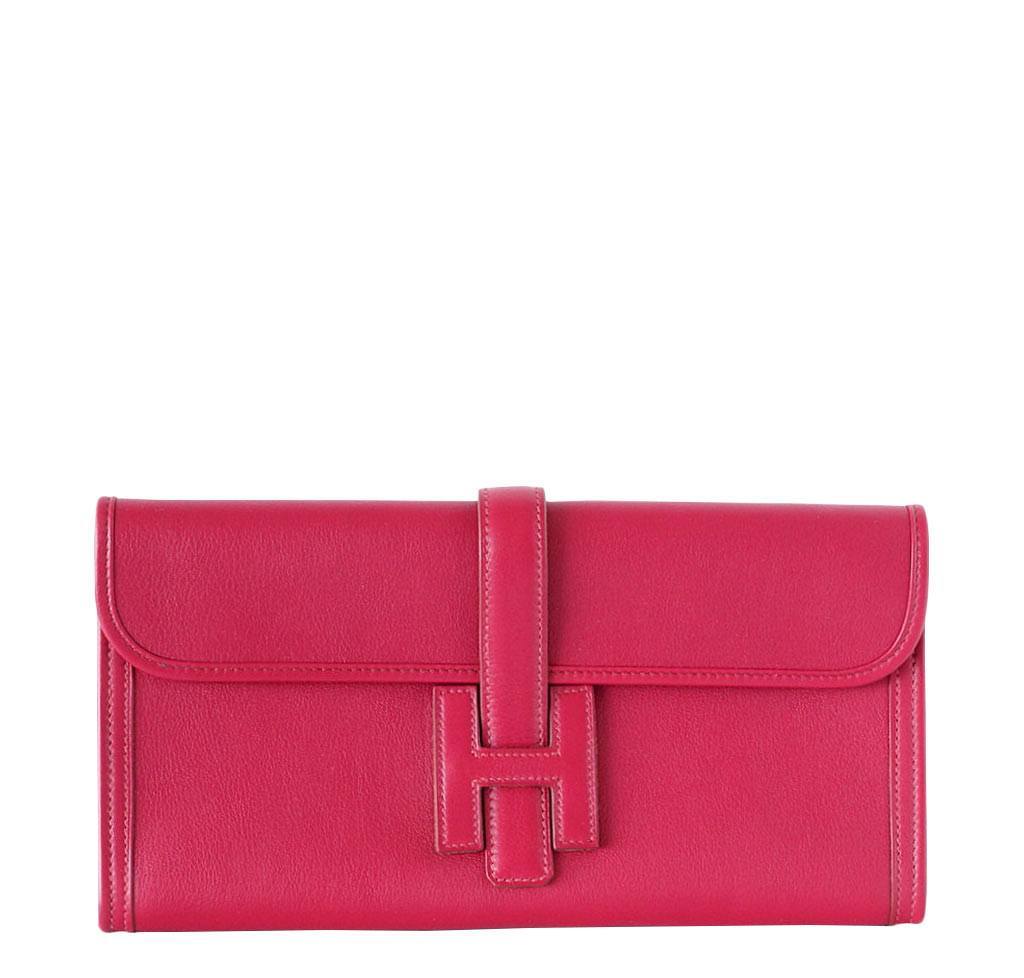 Red clutch bag with a buckle on a white background