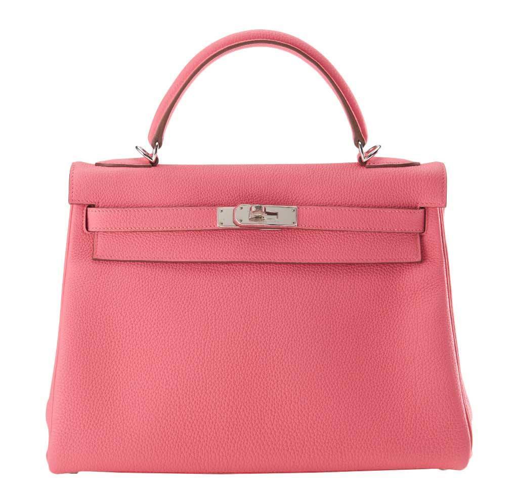 Pink handbag with silver hardware on a white background