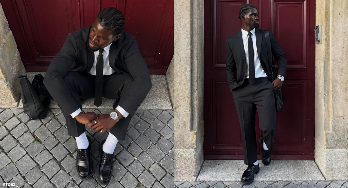 A man in a black suit, white dress shirt, and black tie is shown in two poses in front of dark red doors. One pose has him sitting on stone steps, and the other has him standing on a cobblestone street.